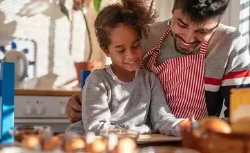 Una niña y un adulto en la cocina